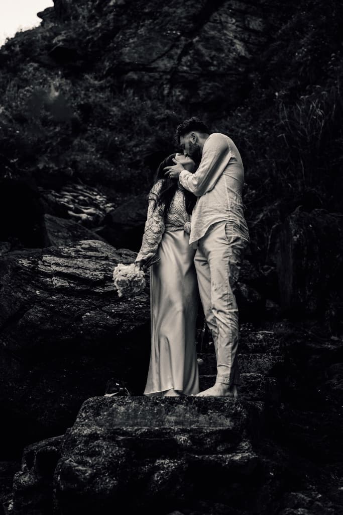 Couple kissing on rocks B&W